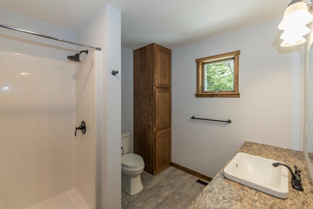 8296 Gladstone Lake Rd, Lake Edward Twp, MN 56401 - full bathroom featuring wood finished floors, toilet, a shower, vanity, and baseboards