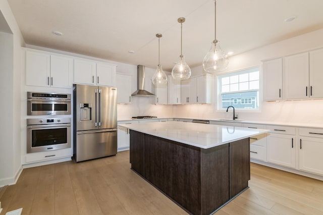 20117 63rd Ave, Corcoran, MN 55340 - kitchen featuring appliances with stainless steel finishes, wall chimney range hood, light wood finished floors, a center island, and light countertops