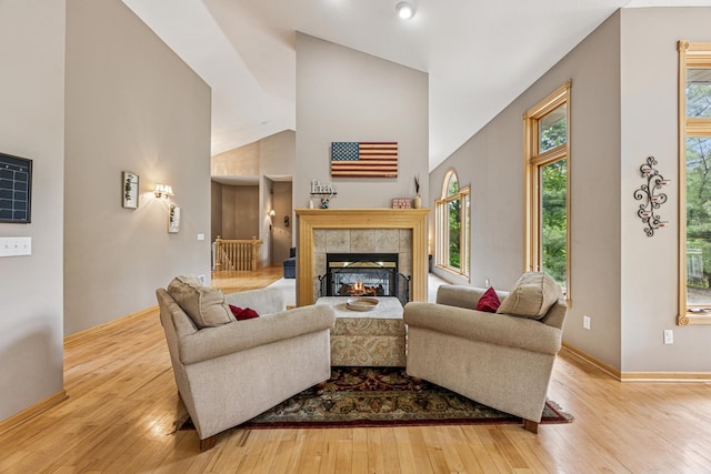 5160 202nd Ln NE, Linwood Twp, MN 55092 - living area featuring wood-type flooring, high vaulted ceiling, baseboards, and a tile fireplace