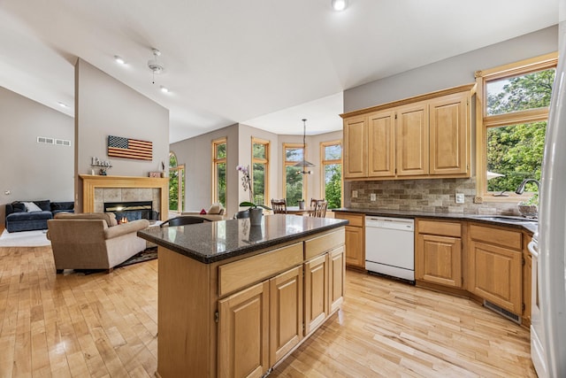 5160 202nd Ln NE, Linwood Twp, MN 55092 - kitchen featuring dishwasher, light wood finished floors, a kitchen island, a tile fireplace, and vaulted ceiling
