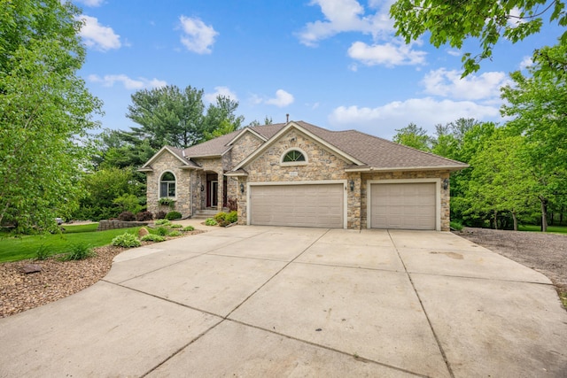 5160 202nd Ln NE, Linwood Twp, MN 55092 - view of front of property with an attached garage, concrete driveway, stone siding, and roof with shingles