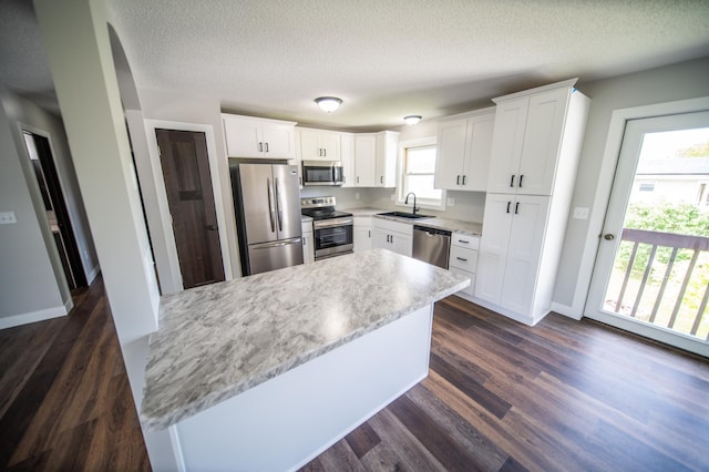 4703 7th St NW, Rochester, MN 55901 - kitchen featuring stainless steel appliances, a sink, dark wood-style floors, white cabinets, and baseboards