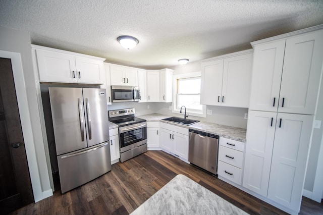 4703 7th St NW, Rochester, MN 55901 - kitchen with appliances with stainless steel finishes, a sink, light countertops, dark wood-style floors, and a textured ceiling