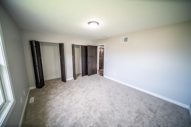 4703 7th St NW, Rochester, MN 55901 - unfurnished bedroom with carpet floors, two closets, and baseboards