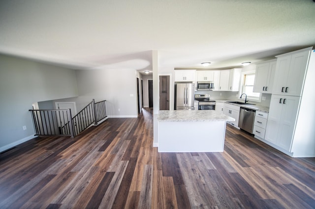 4703 7th St NW, Rochester, MN 55901 - kitchen featuring stainless steel appliances, dark wood-type flooring, white cabinetry, open floor plan, and a kitchen island