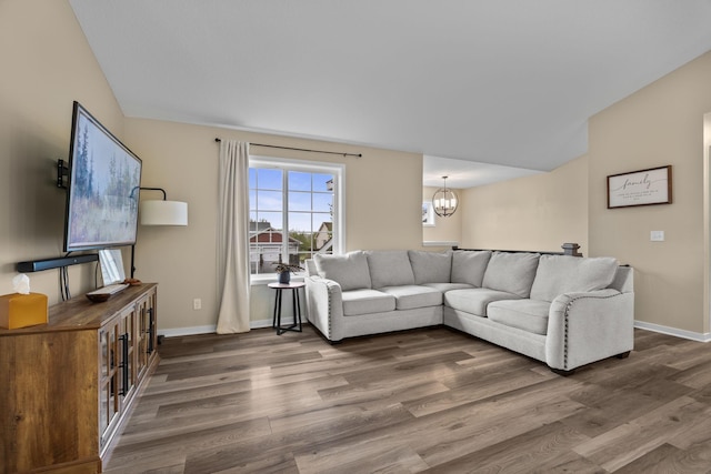 970 Acacia Dr S, Annandale, MN 55302 - living area with a chandelier, wood finished floors, lofted ceiling, and baseboards