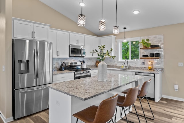 970 Acacia Dr S, Annandale, MN 55302 - kitchen featuring appliances with stainless steel finishes, a sink, white cabinets, vaulted ceiling, and tasteful backsplash