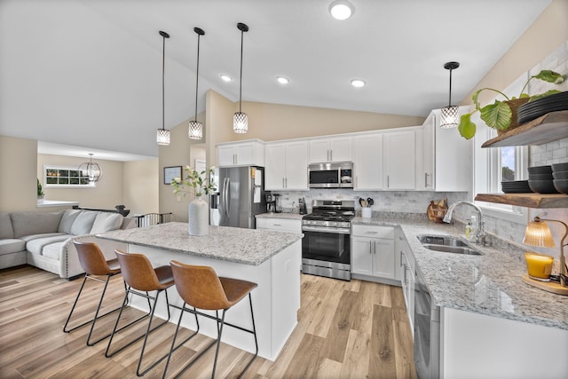 970 Acacia Dr S, Annandale, MN 55302 - kitchen with stainless steel appliances, a sink, a kitchen breakfast bar, white cabinetry, and a center island