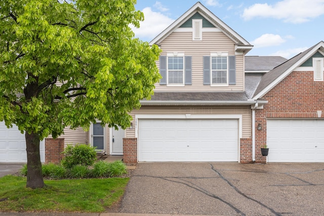 6881 Folkestone Rd Unit 715, Apple Valley, MN 55124 - view of front of house featuring brick siding, driveway, and an attached garage