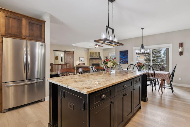 15653 Cobblestone Lake Pkwy, Apple Valley, MN 55124 - kitchen with stainless steel refrigerator, ceiling fan, light wood-style floors, and a barn door