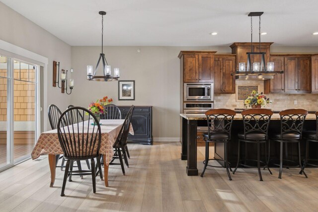 15653 Cobblestone Lake Pkwy, Apple Valley, MN 55124 - kitchen with stainless steel appliances, a chandelier, tasteful backsplash, light wood-type flooring, and light countertops