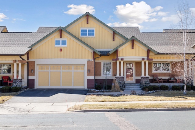 15653 Cobblestone Lake Pkwy, Apple Valley, MN 55124 - craftsman house featuring roof with shingles, asphalt driveway, a garage, a porch, and board and batten siding
