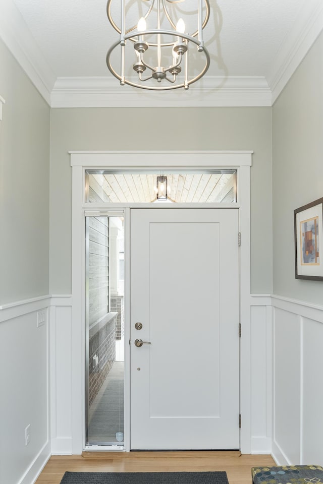 2720 Bentley Dr SW, Rochester, MN 55902 - foyer entrance with a chandelier, ornamental molding, plenty of natural light, light wood-style floors, and wainscoting