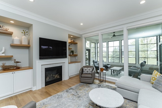 2720 Bentley Dr SW, Rochester, MN 55902 - living area with light wood finished floors, a tile fireplace, ornamental molding, a ceiling fan, and recessed lighting
