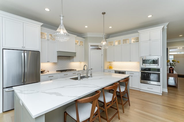 2720 Bentley Dr SW, Rochester, MN 55902 - kitchen featuring stainless steel appliances, a sink, decorative backsplash, crown molding, and an island with sink