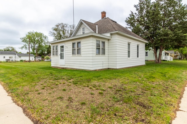 2320 3rd St N, Saint Cloud, MN 56303 - view of property exterior with a lawn, a chimney, and roof with shingles