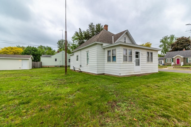 2320 3rd St N, Saint Cloud, MN 56303 - view of home's exterior featuring a chimney, a lawn, and an outdoor structure