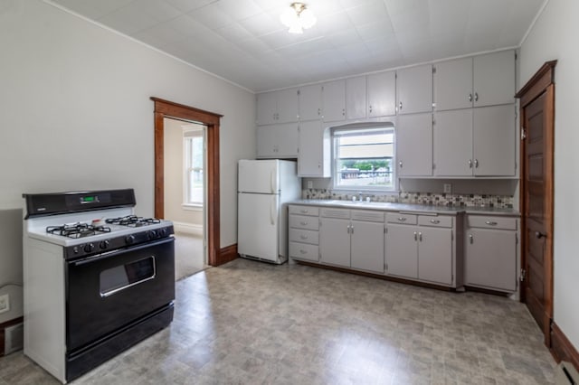 2320 3rd St N, Saint Cloud, MN 56303 - kitchen featuring freestanding refrigerator, gas range oven, a sink, light countertops, and baseboards