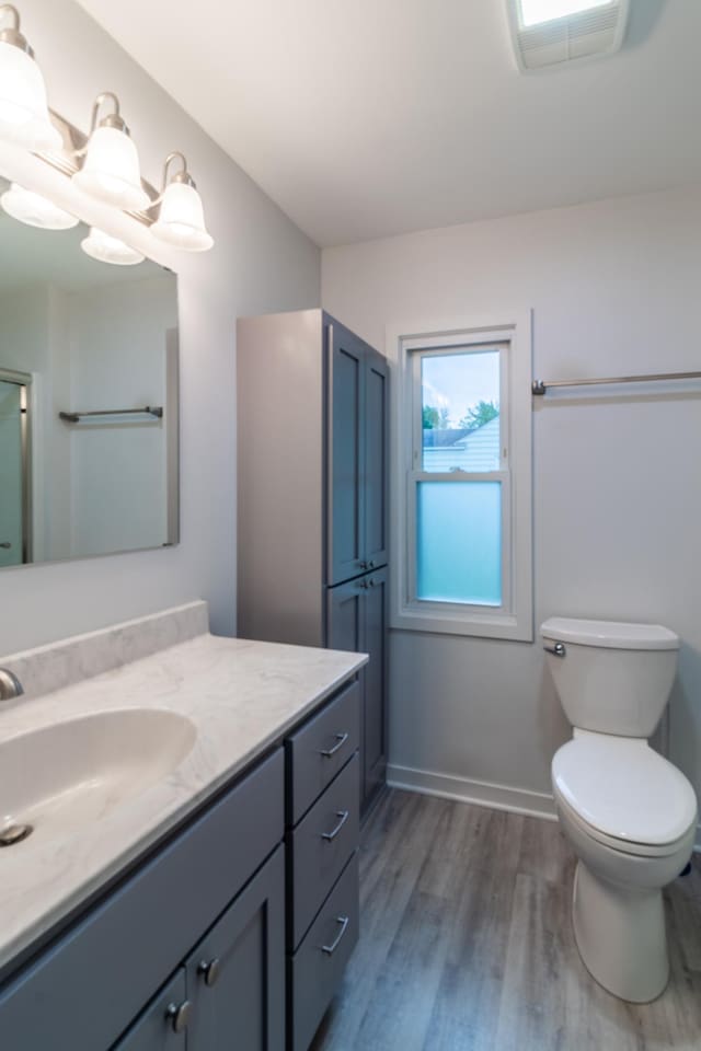 2320 3rd St N, Saint Cloud, MN 56303 - full bathroom with vanity, wood finished floors, toilet, and baseboards
