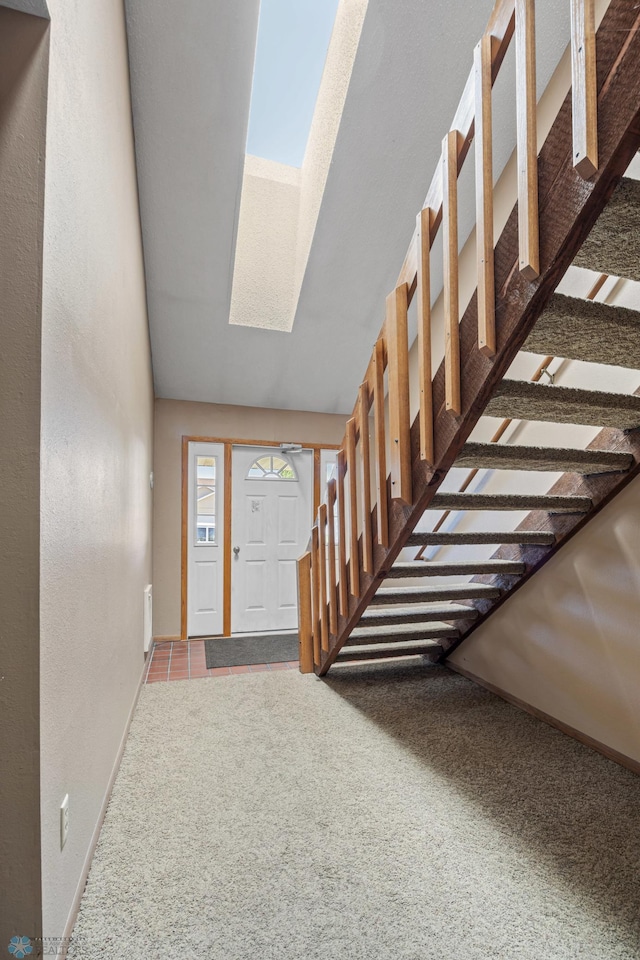 2802 29th Ave S, Moorhead, MN 56560 - entrance foyer with carpet flooring, a skylight, baseboards, lofted ceiling, and stairway