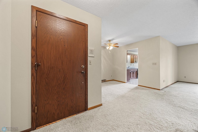 2802 29th Ave S, Moorhead, MN 56560 - empty room with light carpet, baseboards, a ceiling fan, a textured ceiling, and baseboard heating