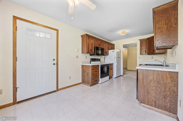 2802 29th Ave S, Moorhead, MN 56560 - kitchen featuring range with electric cooktop, black microwave, a sink, baseboards, and ceiling fan
