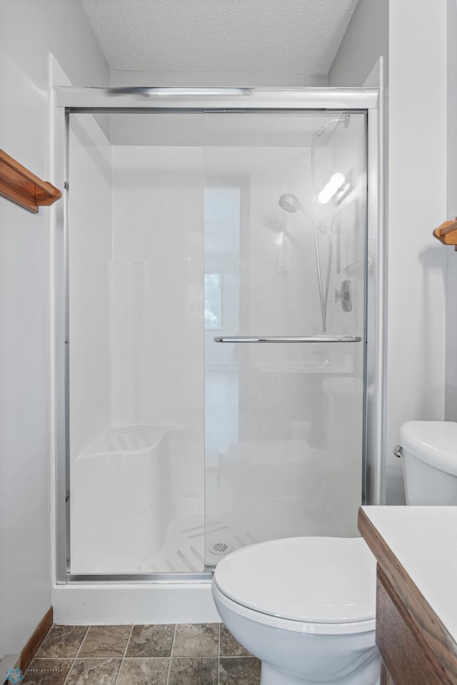 2802 29th Ave S, Moorhead, MN 56560 - bathroom with toilet, vanity, a textured ceiling, and a stall shower