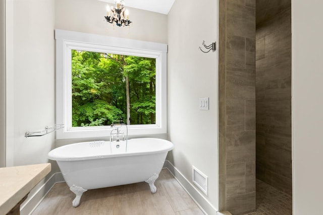 8580 Maple View Dr, Cologne, MN 55322 - full bathroom with a freestanding bath, a chandelier, a tile shower, and baseboards