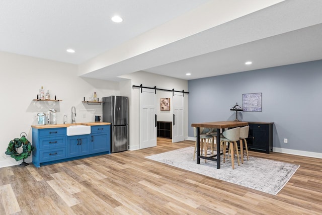 8580 Maple View Dr, Cologne, MN 55322 - kitchen featuring butcher block counters, freestanding refrigerator, blue cabinetry, a sink, and light wood finished floors