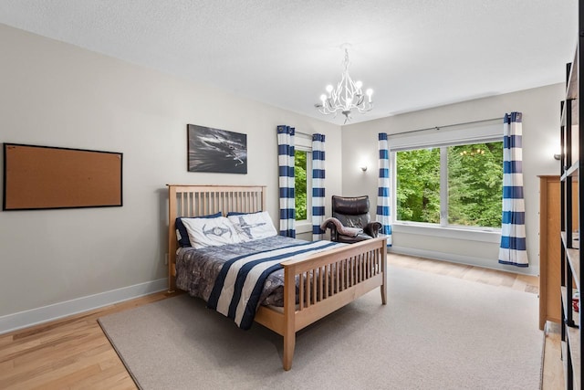 8580 Maple View Dr, Cologne, MN 55322 - bedroom featuring a chandelier, light wood-style flooring, and baseboards