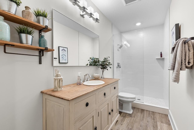 8580 Maple View Dr, Cologne, MN 55322 - bathroom with toilet, vanity, a tile shower, wood finished floors, and recessed lighting