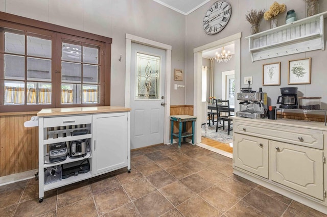 504 4th St, Brainerd, MN 56401 - kitchen with a chandelier, dark stone finish floors, a wainscoted wall, crown molding, and wooden walls