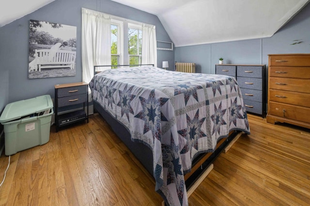 504 4th St, Brainerd, MN 56401 - bedroom featuring radiator, vaulted ceiling, and wood finished floors