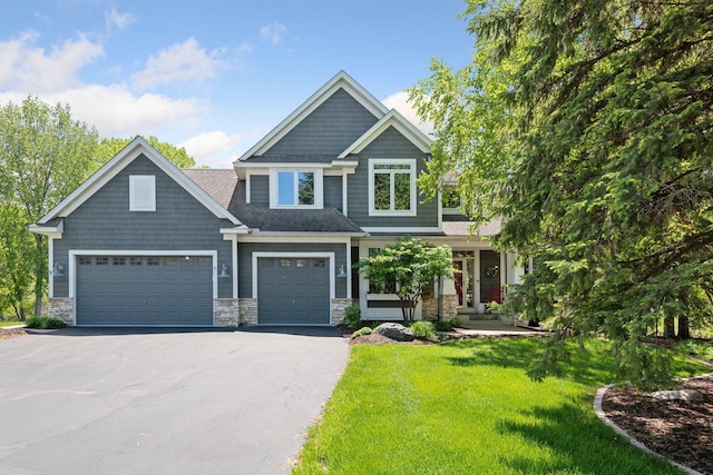 9375 Cold Stream Ln, Eden Prairie, MN 55347 - craftsman inspired home with driveway, stone siding, a front lawn, and an attached garage