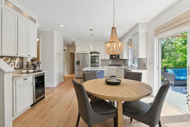 9375 Cold Stream Ln, Eden Prairie, MN 55347 - dining room with wine cooler, a chandelier, light wood-style flooring, recessed lighting, and baseboards