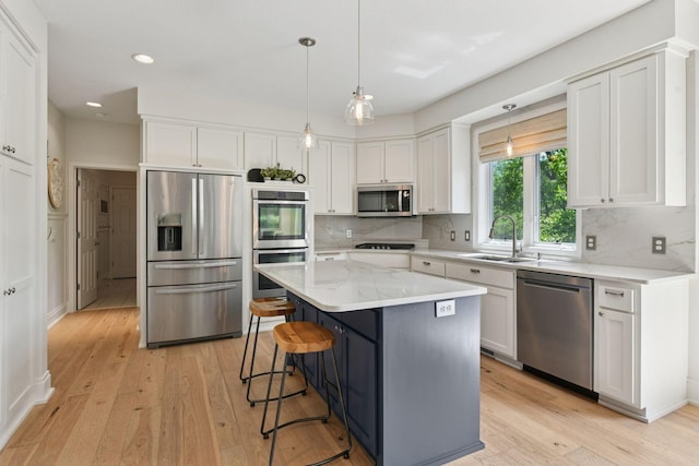 9375 Cold Stream Ln, Eden Prairie, MN 55347 - kitchen with stainless steel appliances, a sink, white cabinetry, light wood-style flooring, and recessed lighting