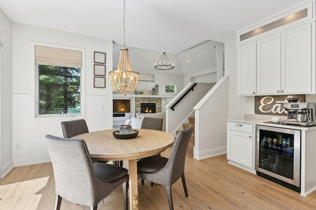 9375 Cold Stream Ln, Eden Prairie, MN 55347 - dining room with wine cooler, a chandelier, light wood-style floors, baseboards, and stairway