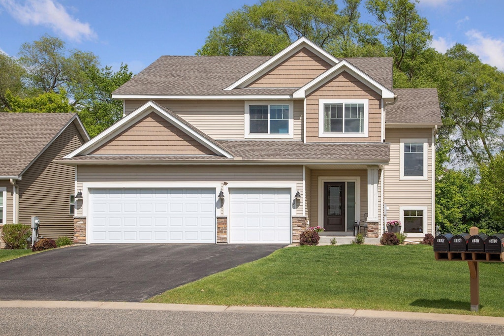 685 Lake Ridge Dr, Woodbury, MN 55129 - view of front of home featuring driveway, roof with shingles, a front lawn, and stone siding