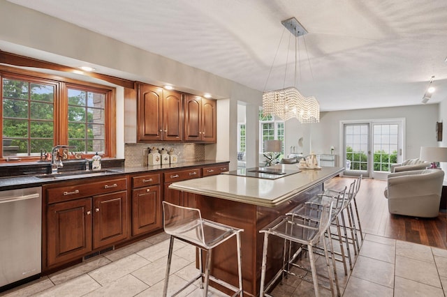 1511 Colleen Ave, Arden Hills, MN 55112 - kitchen with dishwasher, a sink, open floor plan, a kitchen bar, and light tile patterned floors
