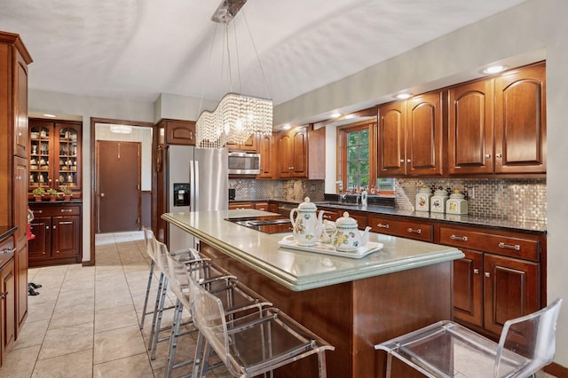 1511 Colleen Ave, Arden Hills, MN 55112 - kitchen featuring appliances with stainless steel finishes, backsplash, a breakfast bar, a kitchen island, and pendant lighting