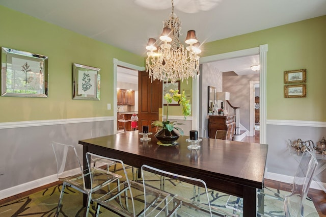 1511 Colleen Ave, Arden Hills, MN 55112 - dining space featuring a chandelier, wood finished floors, baseboards, and stairway