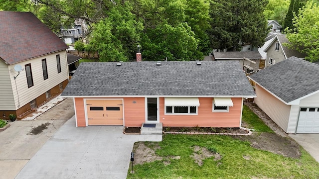 115 1st St SE, Pelican Rapids, MN 56572 - view of front of home with a chimney, concrete driveway, a garage, a shingled roof, and a front lawn
