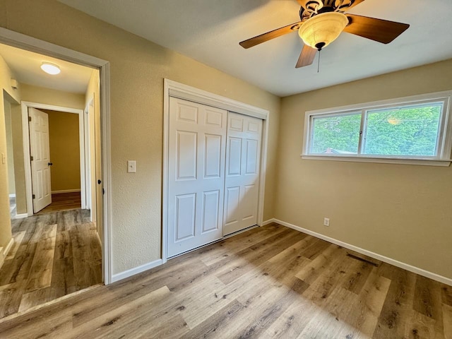 115 1st St SE, Pelican Rapids, MN 56572 - unfurnished bedroom with wood finished floors, a closet, baseboards, and a ceiling fan
