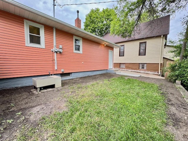 115 1st St SE, Pelican Rapids, MN 56572 - view of property exterior featuring a chimney and a yard