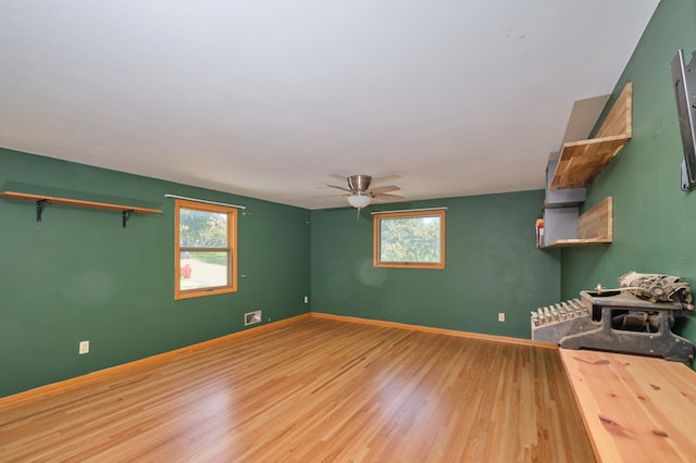 2003 20th Ave NW, Rochester, MN 55901 - unfurnished room featuring plenty of natural light, wood finished floors, ceiling fan, and baseboards