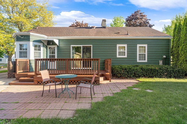 1306 3rd Ave SW, Austin, MN 55912 - rear view of house with a wooden deck, a patio area, a lawn, a chimney, and roof with shingles