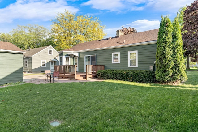 1306 3rd Ave SW, Austin, MN 55912 - back of property featuring a wooden deck, a lawn, a patio, and a chimney