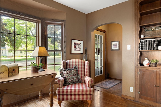 1306 3rd Ave SW, Austin, MN 55912 - living area featuring arched walkways, wood finished floors, a textured wall, and baseboards