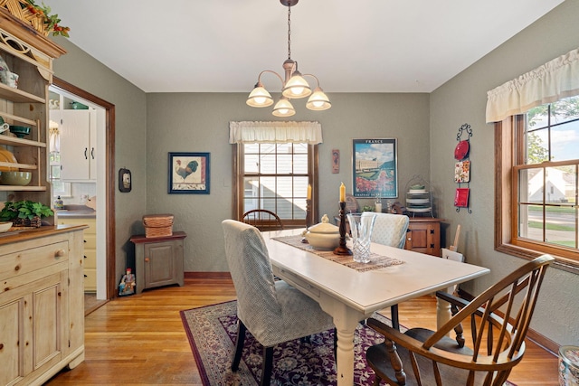 1306 3rd Ave SW, Austin, MN 55912 - dining space featuring a chandelier, light wood-style flooring, a textured wall, and baseboards