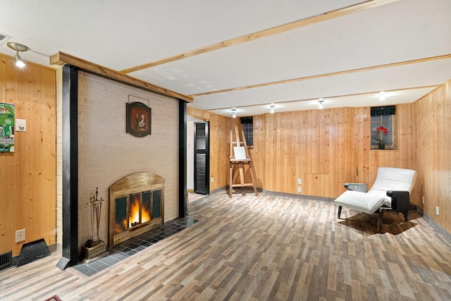 1306 3rd Ave SW, Austin, MN 55912 - unfurnished room featuring wooden walls, wood finished floors, baseboards, and a lit fireplace
